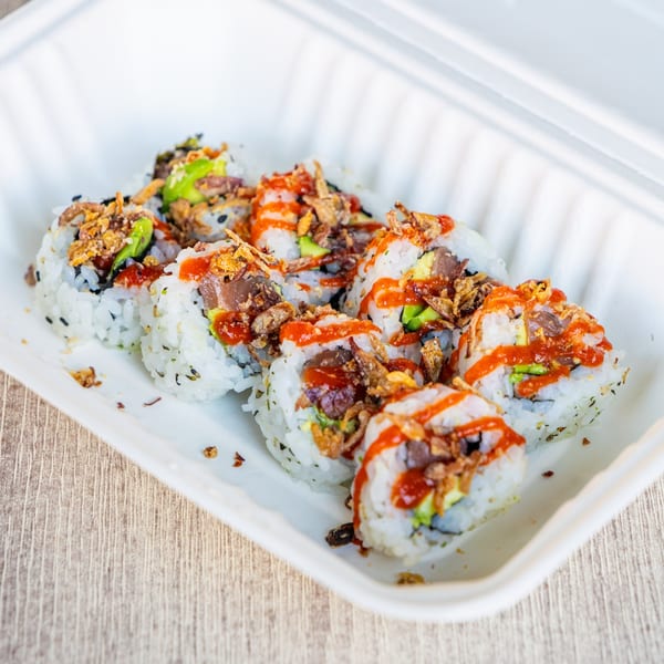 Ramen Kenjo's sushi rolls with avocado, tuna, crispy onions, and spicy sauce in a takeout container.